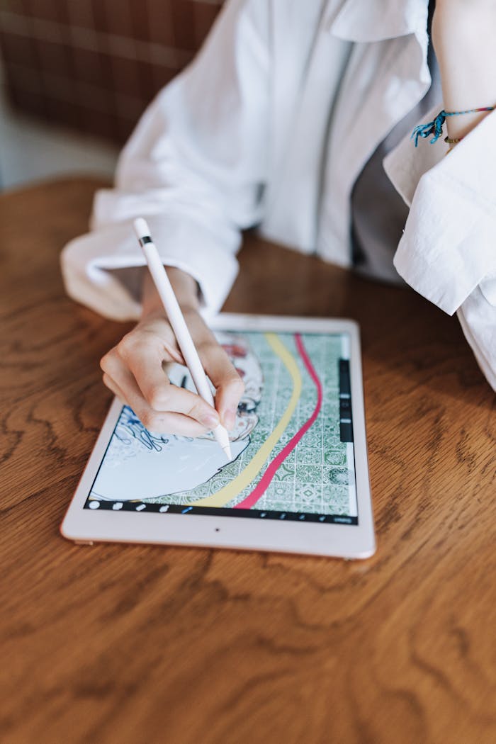 services-03 Woman sketching intricate design on tablet with stylus in contemporary indoor setting.