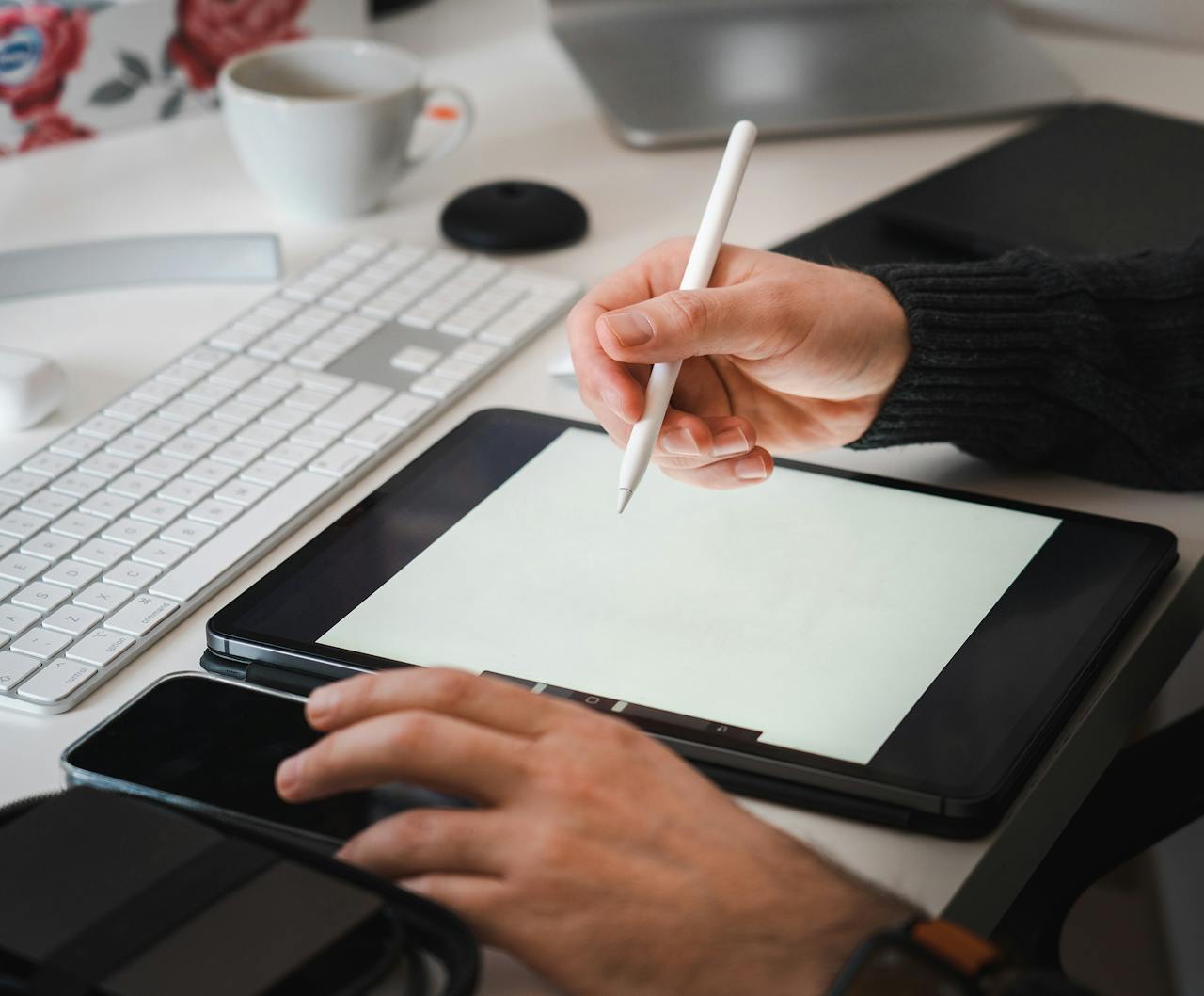 about-01 Designer working with a tablet and stylus in a modern workspace setup.